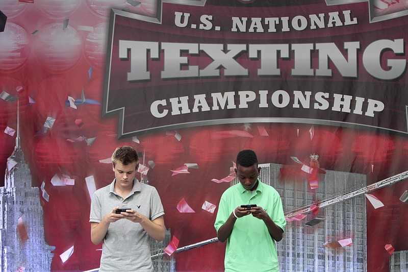 Austin Wierschke, left, of Rhinelander, Wis., and Kent Augustine, of Jamaica, N.Y., compete during the final round of the 2012 LG U.S. National Texting Championship Wednesday in New York.