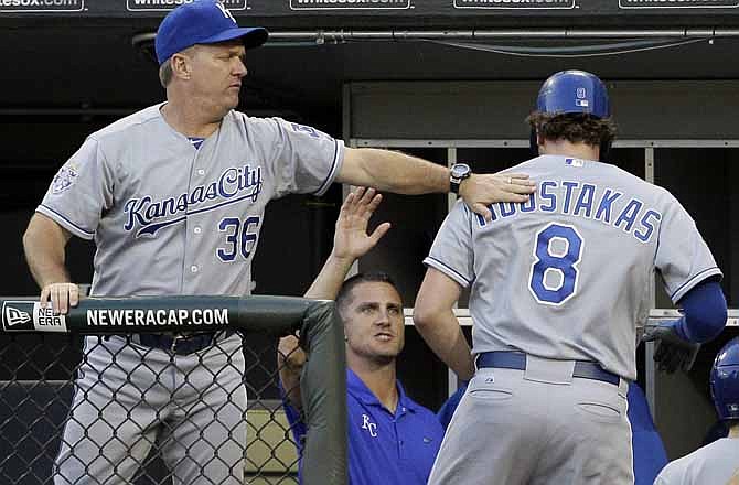Kansas City Royals' Mike Moustakas, right, is congratulated by hitting coach Kevin Seitzer, left, after hitting a solo home run against the Chicago White Sox during the second inning of a baseball game in Chicago, Wednesday, Aug. 8, 2012. 