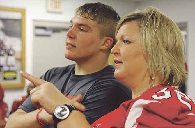 Stephanie Strobel asks questions of her son, Hayden, during Mom's Night on Wednesday at Adkins Stadium. Wednesday night's storm moved the event from the practice field to the film room. 