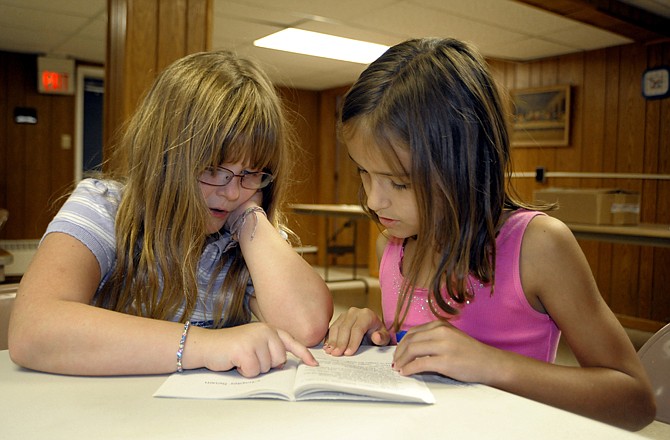 Ashlyn Muessig and Audrey Hudson read together Wednesday afternoon at the Calvary Baptist Church Summer Book Club.