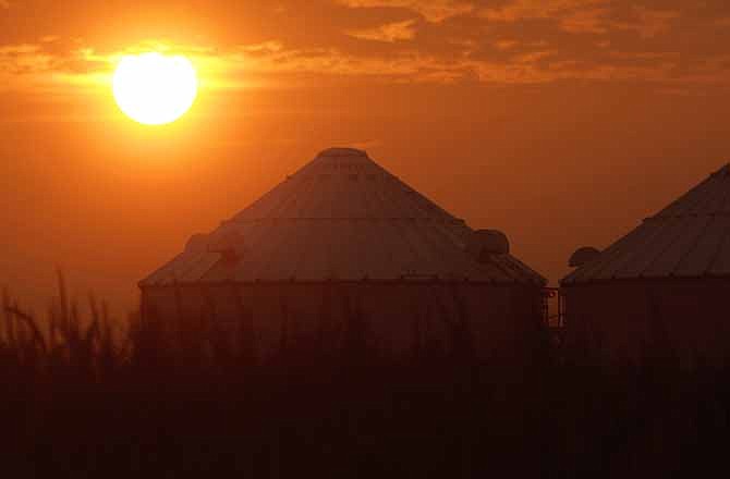 The sun rises over grain bins and a drought struggling corn crop Saturday, Aug. 4, 2012 in Ashland, Ill. The latest U.S. Drought Monitor survey shows an increase in extreme drought conditions in four Plains states. The wide economic impact of this year's drought on crops has yet to be seen but some cattle farmers are already selling off their livestock rather than endure the higher cost of feed.