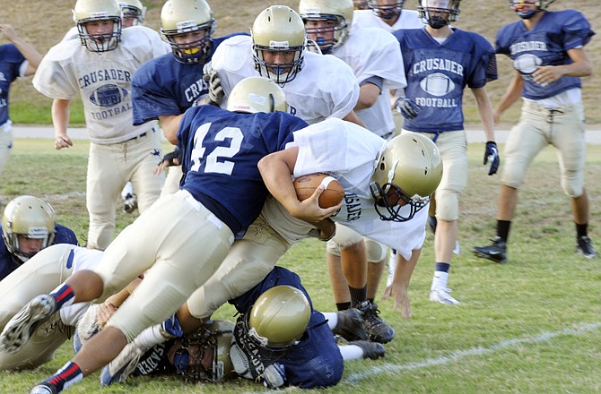 Justus Schulte of Helias falls forward for extra yardage during a Crusader scrimmage. Helias will participate in a Jamboree tonight.
