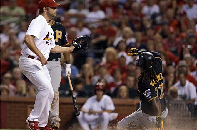 Pittsburgh Pirates' Andrew McCutchen, right, scores on a passed ball as St. Louis Cardinals starting pitcher Jake Westbrook, left, covers home during the fourth inning of a baseball game Friday, Aug. 17, 2012, in St. Louis. 