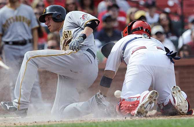 Pittsburgh Pirates' Clint Barmes, left, scores on a hit by Jordy Mercer as St. Louis Cardinals catcher Yadier Molina can't make the tag in the third inning of a baseball game Saturday, August 18, 2012, in St. Louis. 