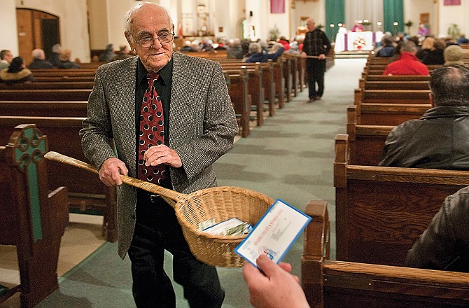 John Alves, of Dartmouth, Mass., uses a basket while taking collection during Mass at St. John the Baptist Roman Catholic Church in New Bedford, Mass. A study on the generosity of Americans found that states with populations that are less religious are also the stingiest about giving money to charity.