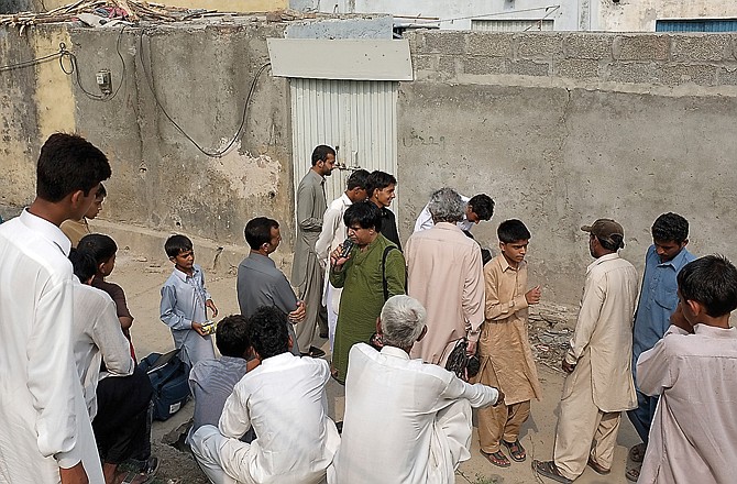 People continued to gather Monday outside the locked house of a Christian girl in suburbs of Islamabad, Pakistan. Authorities arrested a Christian girl and are investigating whether she violated the country's strict blasphemy laws after furious neighbors surrounded her house and demanded police take action.