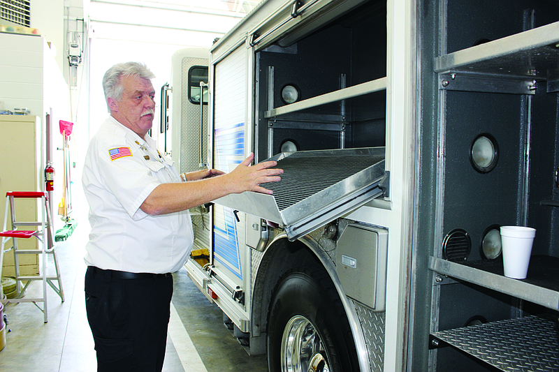Fulton fire chief Dean Buffington shows off a compartment designed to hold and organize tools in the 2004 American LaFrance fire truck the department recently acquired Wednesday. Buffington said the truck had several features designed to shave crucial seconds off of a response team's setup time.