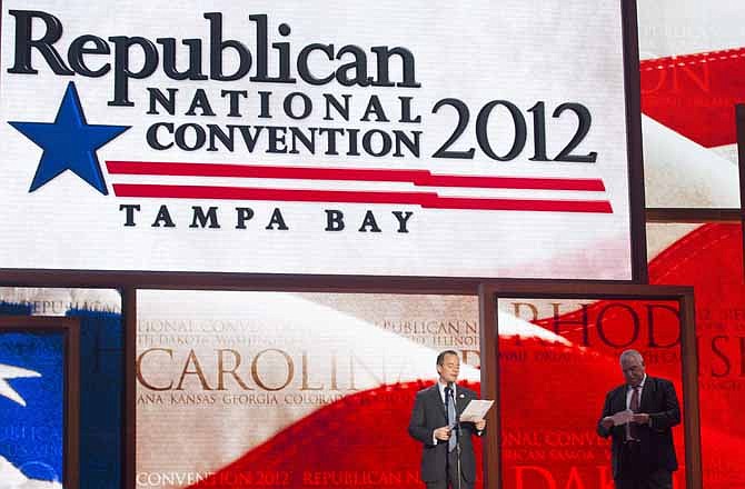 Republican National Committee Chairman Reince Priebus, left, and convention CEO William Harris unveil the stage and podium for the 2012 Republican National Convention, Monday, Aug. 20, 2012, at the Tampa Bay Times Forum in Tampa, Fla.