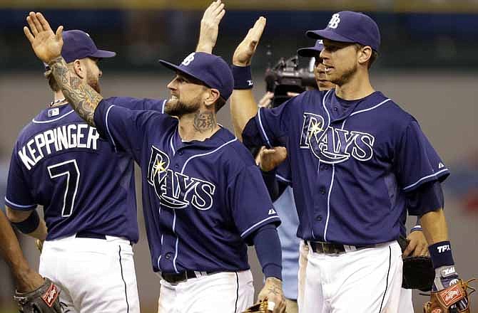 Tampa Bay Rays, from left, Jeff Keppinger, Ryan Roberts, and Ben Zobrist react after the team defeated the Kansas City Royals 5-3 in a baseball game Wednesday, Aug. 22, 2012 in St. Petersburg, Fla.