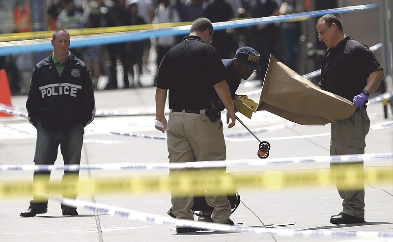 Officials collects evidence near the Empire State Building following a shooting Friday in New York. Police say Jeffrey Johnson, 58, a recently laid-off worker, shot a former colleague to death near the iconic skyscraper.