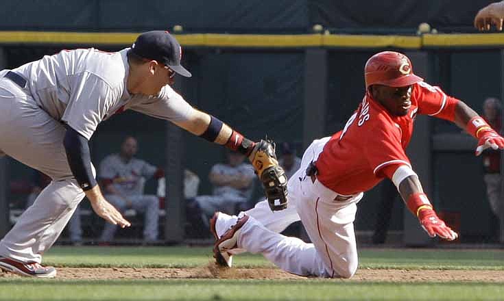 Cincinnati Reds' Brandon Phillips, right, dives safely back to first base, avoiding the tag by St. Louis Cardinals first baseman Allen Craig, after being caught in a rundown in the third inning of a baseball game on Saturday, Aug. 25, 2012, in Cincinnati.
