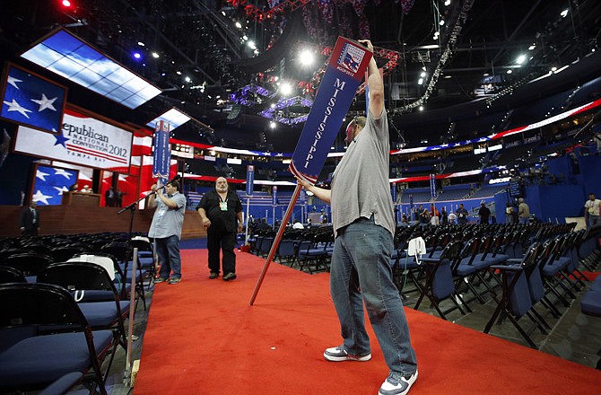 Jason Bottomley places the Mississippi delegation sign in the proper place before the Republican National Convention in Tampa, Fla. on Sunday.