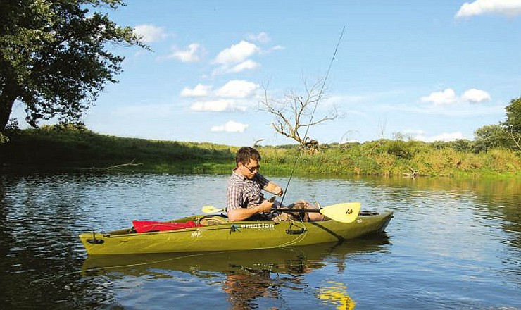 Ben Shadley catches another smallmouth from a kayak in a small stream.
