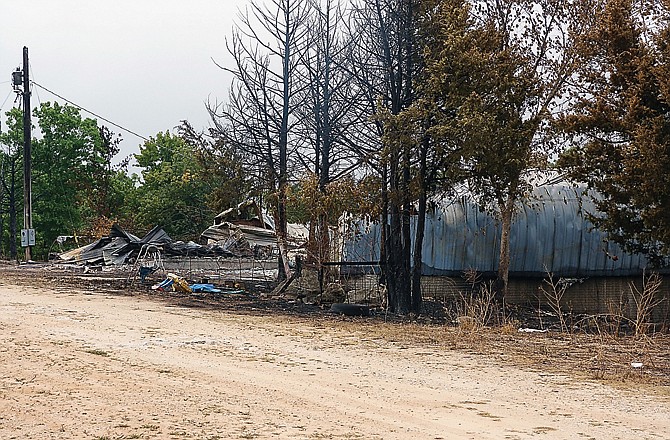 A pile of charred rubble is all that is left of this barn along Missouri 42 in Miller County. The barn, along with two other unoccupied structures and 400-500 acres of brush and timberland were destroyed in a wildfire last week.