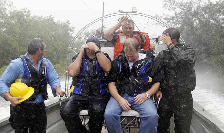 Bay St. Louis, Miss., first responders brave a driving rain storm as they use an airboat to reach a house fire in a flooded subdivision, Tuesday, Aug. 28, 2012. After several attempts to reach the house fire, flooded streets forced the fire fighters to use the airboat. 