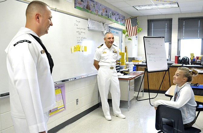 USS Missouri sailor Wilfred Dumont, near, answers a question posed by Lewis & Clark Middle School seventh-grader Rain Cross, at right. In the background is Cmdr. Mike Luckett, who talked about leading the crew and the ship on its voyage.