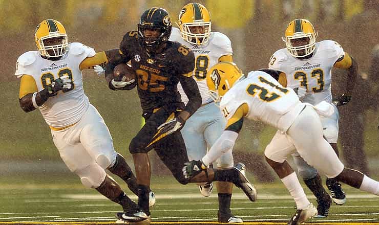 Missouri wide receiver Marcus Lucas (85) is chased by Southeastern Louisiana defenders after catching a pass for a 21-yard gain as a steady rain falls during the second quarter of an NCAA college football game Saturday, Sept. 1, 2012, in Columbia, Mo.