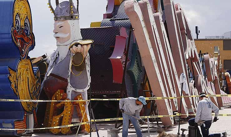 In this photo taken Thursday, Aug. 30, 2012, electricians Luis Varela, left, and Aaron Chastain work together to install the base of a lighting fixture on the grounds of the soon to open Neon Museum in Las Vegas. (AP Photo/Las Vegas Review-Journal, Jason Bean)