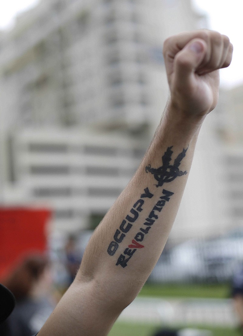 Occupy Demonstrators shout at police and raise their fists Tuesday during an unscheduled protest march in Charlotte, N.C. The Democratic National Convention begins today.