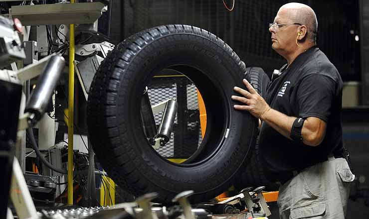 In this Tuesday, July 24, 2012, photo, tire inspector Buddy Rice checks for defects in the tire verification area at a Michelin manufacturing plant in Greenville, S.C. U.S. factory activity shrank for the third straight month in August as new orders, production and employment all fell. The report adds to other signs that manufacturing is struggling around the globe.