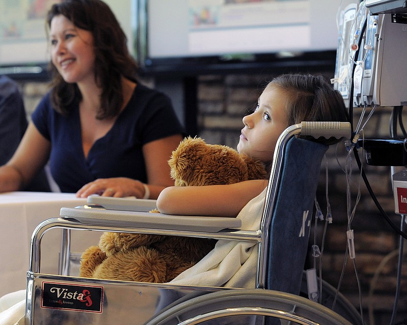 Seven-year-old Sierra Jane Downing, from Pagosa Springs, Colo., watches Wednesday while her father Sean Downing and mother Darcy Downing talk about her recovery from bubonic plague at the Rocky Mountain Hospital for Children at Presbyterian/St. Luke's during a news conference in Denver. It is believed Downing caught the bubonic plague from burying a dead squirrel.