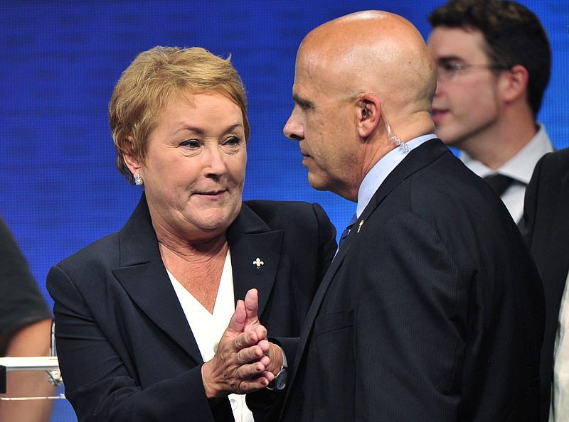 Parti Quebecois Leader Pauline Marois speaks with a member of her security detail Tuesday after being whisked off the stage by Surete du Quebec police officers as she delivered her victory speech in Montreal, Que. Police were not immediately able to provide details but party organizers informed the crowd that there had been an explosive noise and they needed to clear the auditorium.