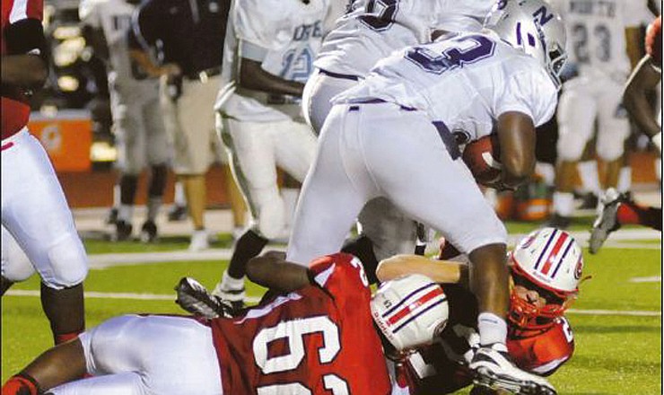 Hakeem Chism (62) and Gabe Marcantonio (2) combine to bring down McCluer North running back Brandon Minor earlier this season at Adkins Stadium. The Jays will host Fayetteville, Ark., on Friday.