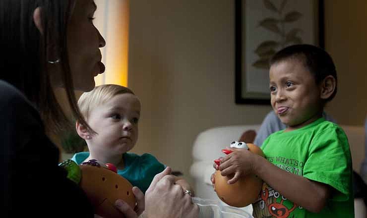 In this Thursday, Sept. 6, 2012 photo, Jessica Hooker, left, playfully sticks out her tongue as she plays with her adopted son Daniel, right, and daughter Ellyson, center, in Guatemala City. Daniel was 18 months old when the Tennessee couple Ryan and Jessica Hooker began the process to adopt him in Guatemala. They just got him at age 6. 