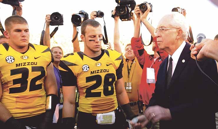 Southeastern Conference commissioner Michael Slive prepares to toss the coin before the start of Saturday's game between Missouri and Georgia in Columbia, Mo.