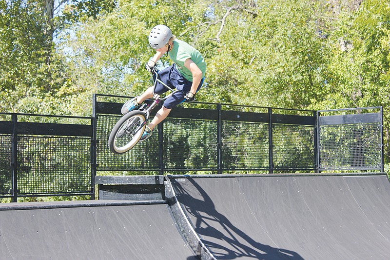 Brandon Price, 14, enjoys the cooler weather following last weekend's storms as he shows off his BMX moves at Veterans Park Monday.