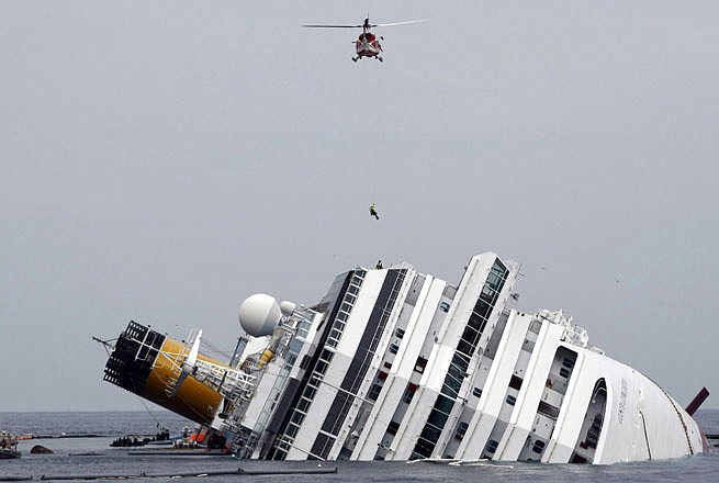 An Italian firefighter is lowered from a helicopter onto the grounded cruise ship Costa Concordia in January. Despite legal obstacles that might force them to sue in Italy, hundreds of Costa Concordia passengers are pressing ahead with U.S. lawsuits seeking millions of dollars in damages from Miami-based Carnival Corp. 