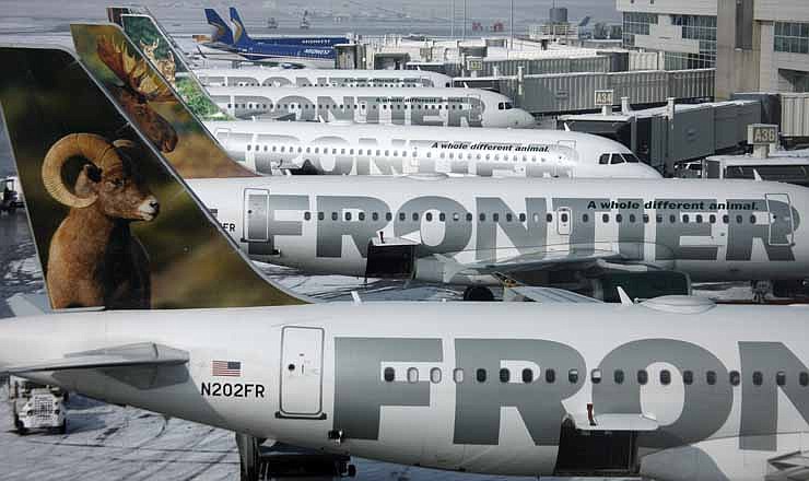 In this Monday, Feb. 22, 2010, file photo, Frontier Airlines jetliners sit stacked up at gates along the A concourse at Denver International Airport. Carriers are offering more deals to passengers who book flights directly on their websites. Frontier Airlines is the latest carrier to jump into the fight, announcing Wednesday, Sept. 12, 2012, that it will penalize passengers who don't book directly with the airline. 