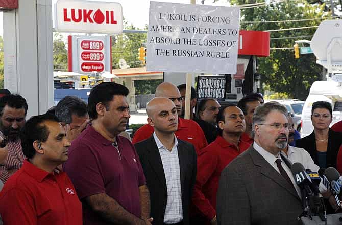 Sal Risalvato, second right, answers a question at a Lukoil service station Wednesday, Sept. 12, 2012, in South Plainfield, N.J., as a large gathering of Lukoil dealers and workers protested what they say are unfair pricing practices by Lukoil North America. 