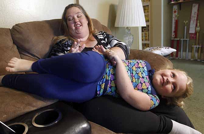 In this photo taken Monday, Sept. 10, 2012, seven-year-old beauty pageant regular and reality show star, Alana "Honey Boo Boo" Thompson, plays with her mother June Shannon during an interview in her home in McIntyre, Ga.