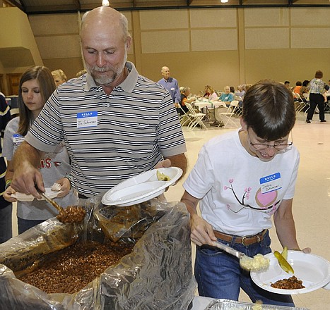 Debbie and Jim Schwarzer grab some barbecue Thursday as the Samaritan Center celebrated 25 years by treating around 300 volunteers to Lutz's BBQ at the Capital Events Center.