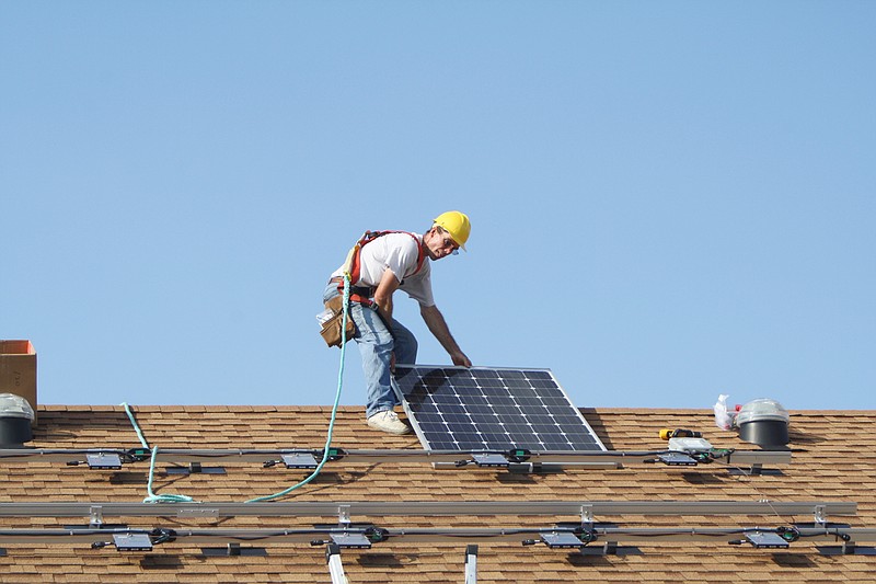 Son Solar Systems co-owner Delwin Dowd installs a solar panel Thursday on the roof of the house owned by Judy McKinnon and Jim Stevermer in Fulton. The couple is the first household in Fulton to use net metering.