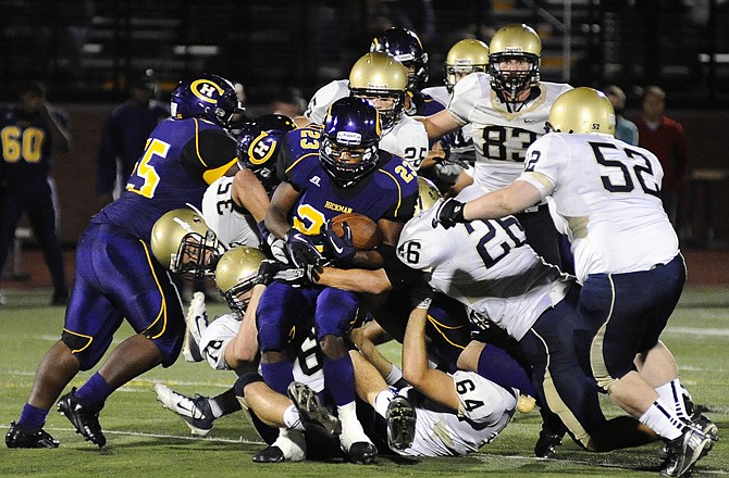 Hickman running back Deven Larry gets stood up at the line of scrimmage by a host of Helias defenders during Friday's game in Columbia.