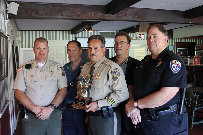 County Sheriff Dennis Crane, center, poses with his G.W. Law Award with some past recipients of the award. From left: CCSO deputy Jackie Karhoff, 2011 recipient; Missouri State Highway Patrol corporal Mike Turner, 2003 recipient; CCSO investigative sergeant Bob Smith, 1998 recipient; and Fulton Police Department chief Steve Myers, 2000 recipient.