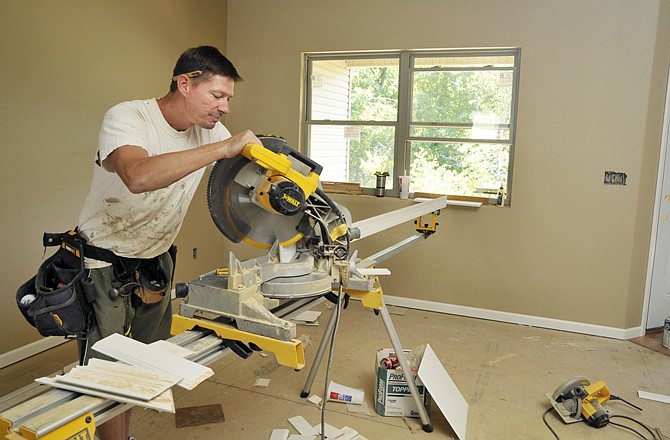 Jason Stock cuts pieces of baseboard as he works on new house construction in Jefferson City. Stock works for Ryan Schrimpf Construction, whose company is nearing completion on this tri-plex.