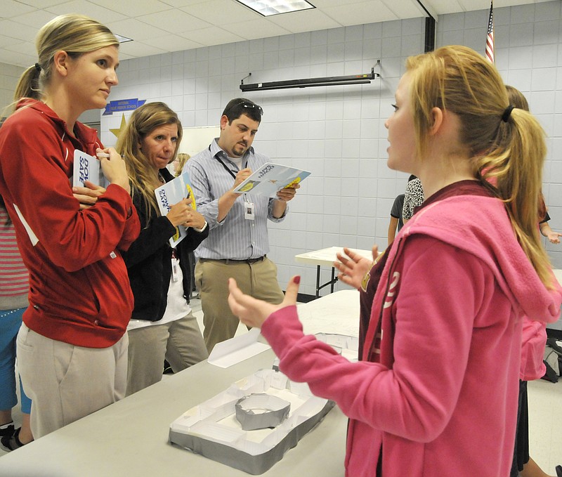 A team, made up of Madison Hiatte, near, Madeline Mitchell and Mikayla Thomas, explain their ideas to Simonsen Ninth Grade Center counselors, Jamie Marshall, left, Carrie Phillips and Tim Ritter. The students wanted to create a multi-level building for their academy. Their idea even had a round cafeteria with the banks of lockers encircling the lunchroom.