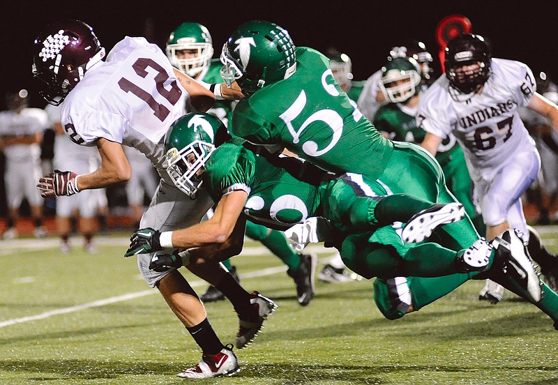 Blair Oaks' Tyler Clutts (16) and Zach Holstein (52) tackle Osage's Tyler Jones (12) during Friday's game in Wardsville.