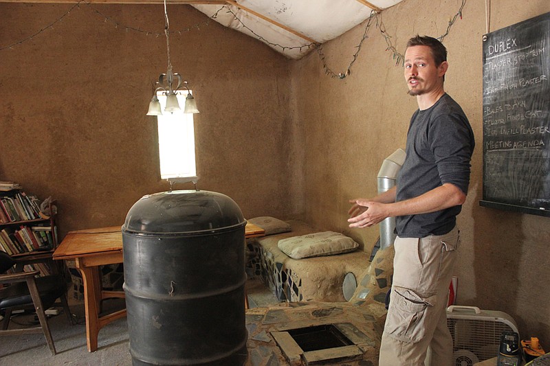 Tao Weilundemo explains how the rocket stove works in the straw-bale common building he and his friends built as proprieters of Maya Creek, a sustainable living education center in Callaway County. Devoted to sustaining the Earth and self-sufficiency, Maya Creek hosts free workshops throughout the year for the general public to learn about topics ranging from growing mushrooms and building with natural materials to compost toilets.