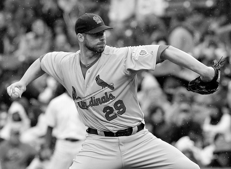 As rain falls, Cardinals starter Chris Carpenter throws against the Cubs during the first inning Friday in Chicago.