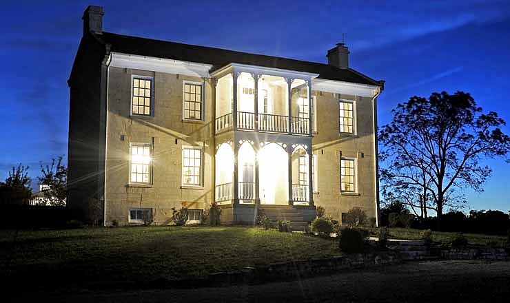 Lights at the historic Colonel Lewis Bolton home burn bright as the historic Wardsville, Mo., house glows against the early evening sky in this September 2012 photo.