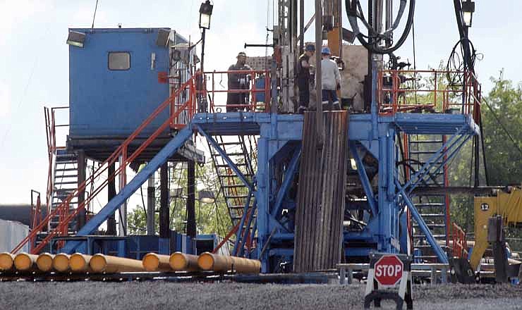 In this June 25, 2012 file photo, a crew works on a gas drilling rig at a well site for shale based natural gas in Zelienople, Pa. 