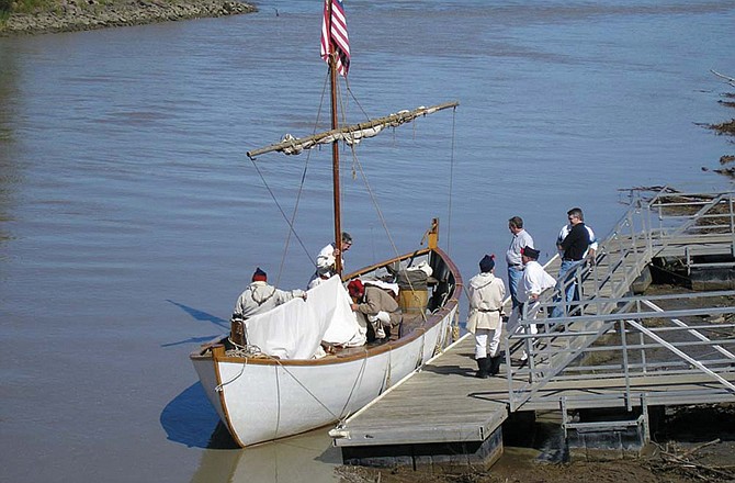 Lewis and Clark reenactors from St. Charles are depicted here mooring the white pirogue at Fort Pierre, S.D., in 2004.