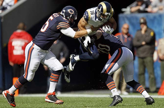 Danny Amendola of the Rams leaps in the air as he is tackled by Bears teammates Patrick Mannelly and safety Craig Steltz in the second half of Sunday afternoon's game in Chicago.