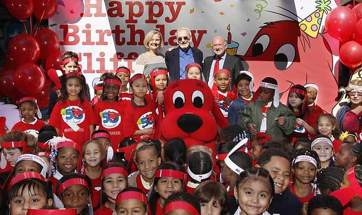 This image released by Scholastic shows first graders celebrating Clifford the Big Red Dog's 50th anniversary, along with his creator Norman Bridwell, center rear, his daughter Elizabeth, left, and Scholastic CEO Dick Robinson at Scholastic's headquarters in New York, Monday, Sept. 24, 2012. 