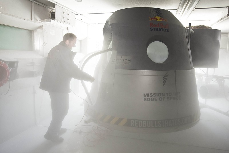 A crew member adjusts the space capsule of the Red Bull Stratos mission in the pressure chamber at Brooks Air Force Base in San Antonio, Texas. Skydiver Felix Baumgartner will attempt to go supersonic when he jumps from the capsule at a record altitude of 23 miles over New Mexico. Project managers announced the jump is scheduled for Oct. 8.