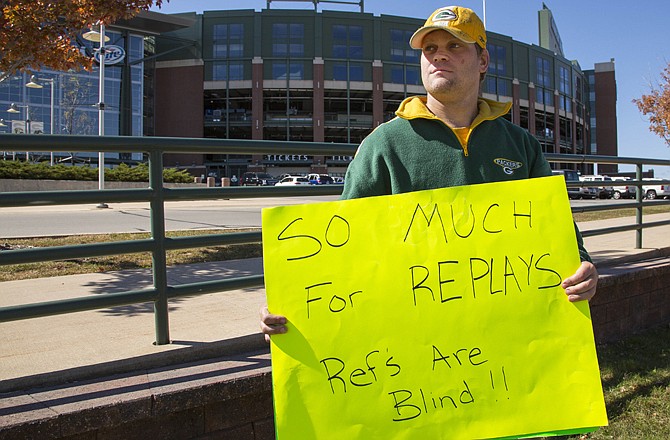 Packers fan Mike LePak holds a sign in front of Lambeau Field on Lombardi Avenue on Tuesday in Green Bay, Wis., in protest of a controversial call in Green Bay's 14-12 loss to the Seahawks on Monday night in Seattle.